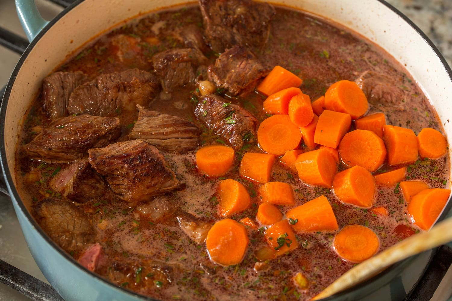 Browned beef chuck and carrots added to stew.