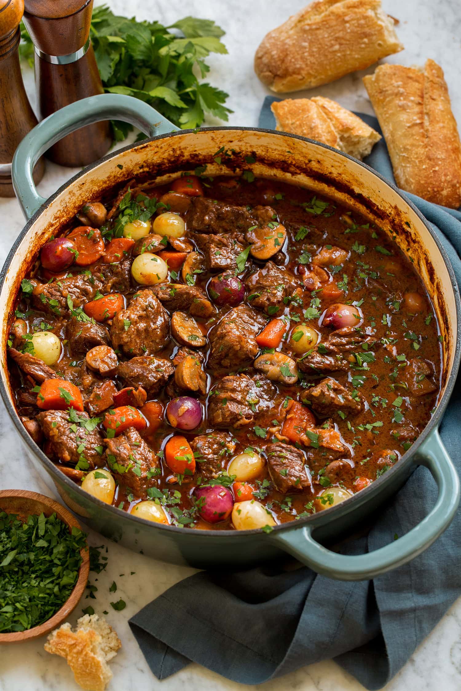 Beef bourguignon in a blue wide braiser pot.