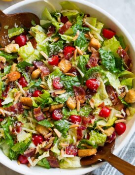 The Best Salad in a large salad bowl. Salad includes romaine lettuce, bacon, croutons, parmesan, swiss cheese, almonds, grape tomatoes and lemon vinaigrette dressing.