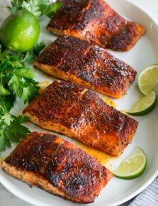 Photo: Blackened salmon shown topped with buttery honey lime sauce. Parsley and limes are shown as garnishes.