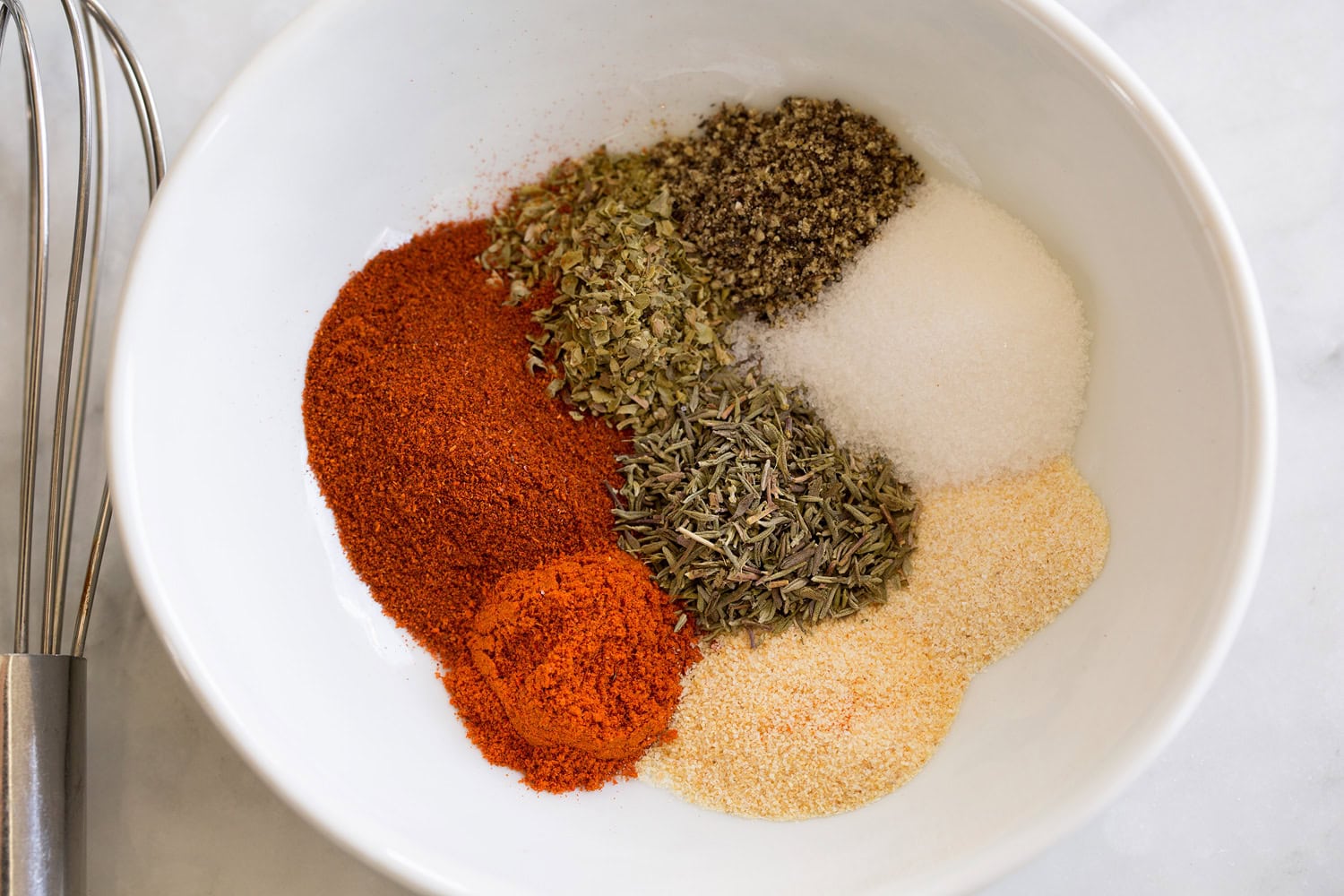 Blackened shrimp seasoning in a white small bowl. Shown before mixing spices.