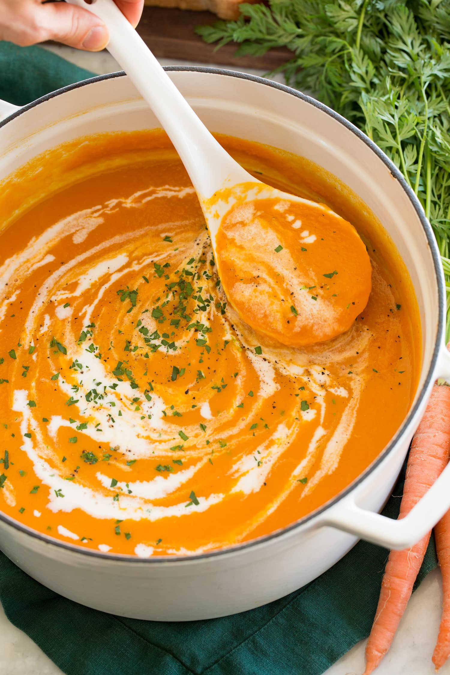 Close up photo of carrot soup swirled with coconut milk.