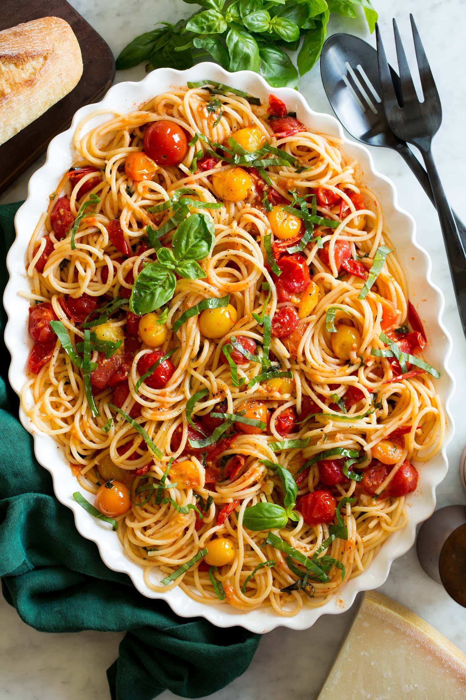 Cherry tomato pasta on a white oval scalloped serving platter.