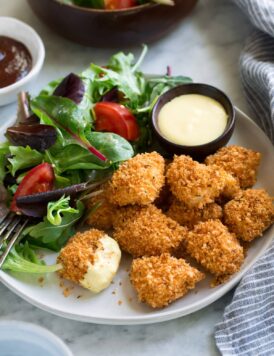 Chicken Nuggets on a serving plate with a side salad.