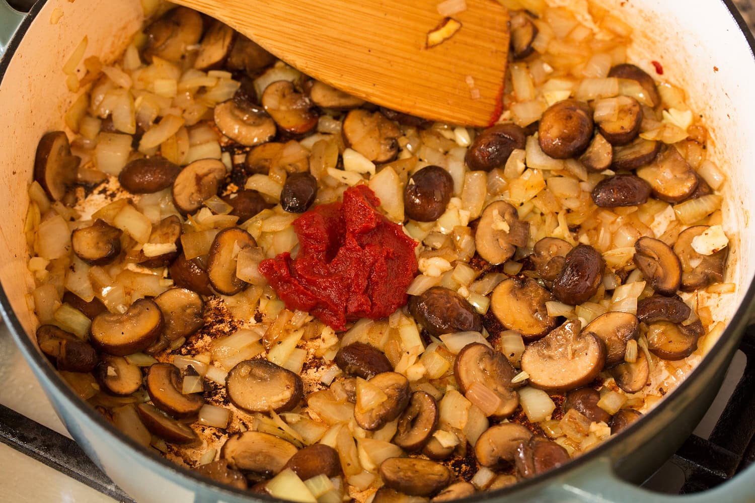 Mushrooms, onions, garlic and tomato paste browned in a pot.