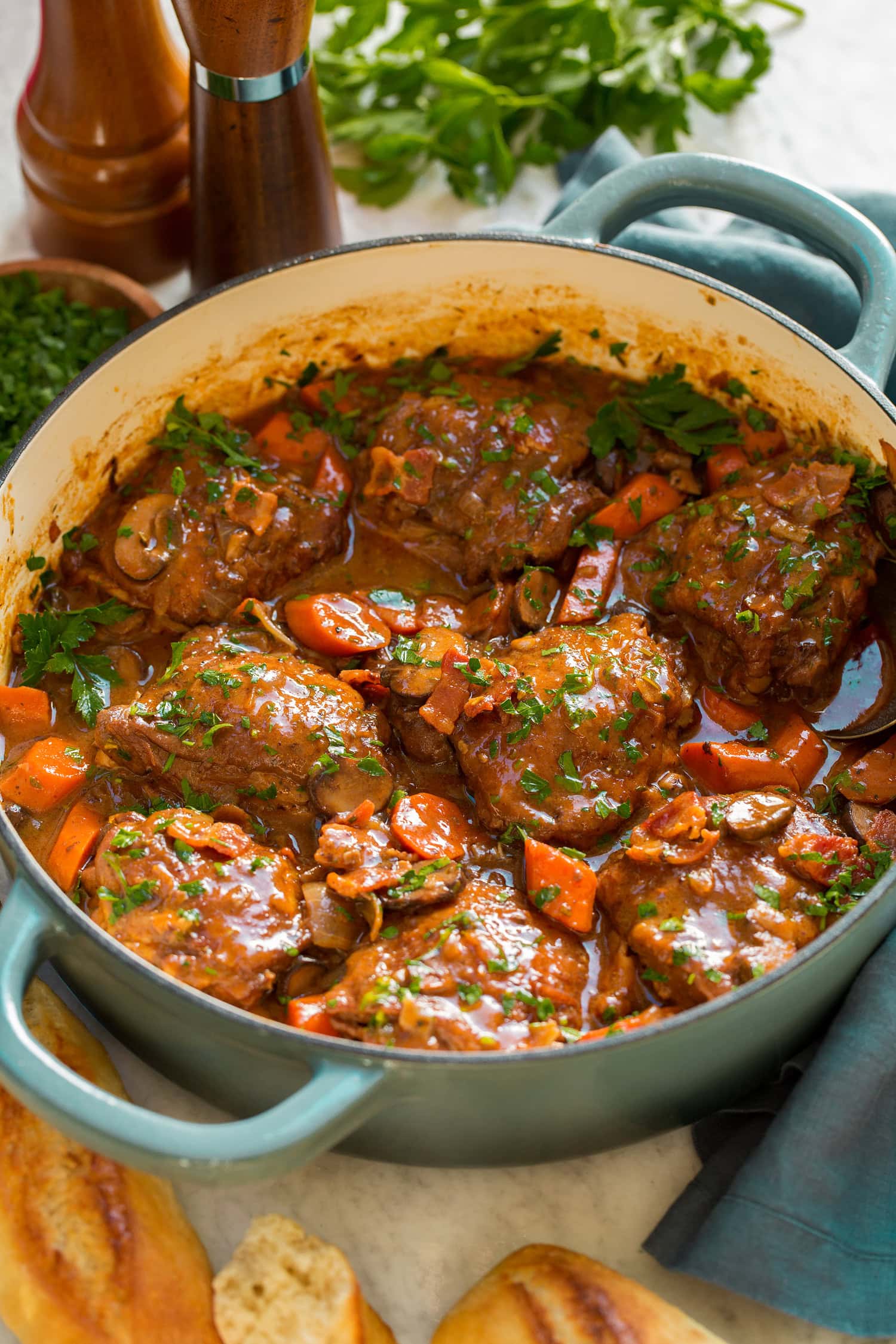 Coq au vin shown in a braiser pot.