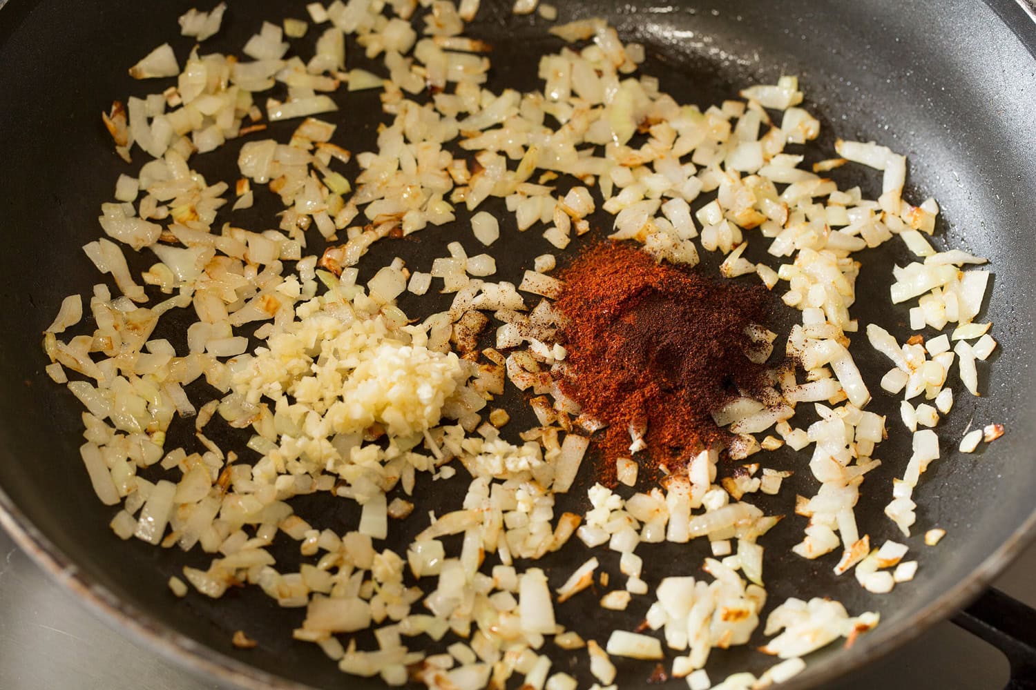 Sauteed onions with garlic and chili powder in skillet.