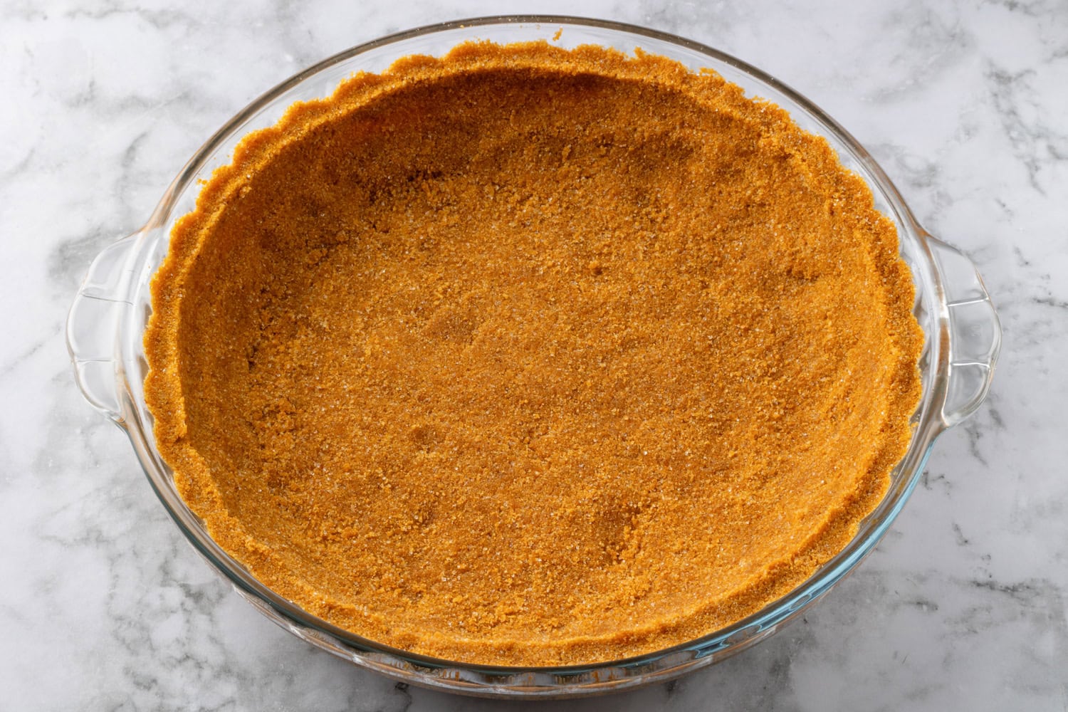 Graham cracker crust mixture pressed into a pie dish.