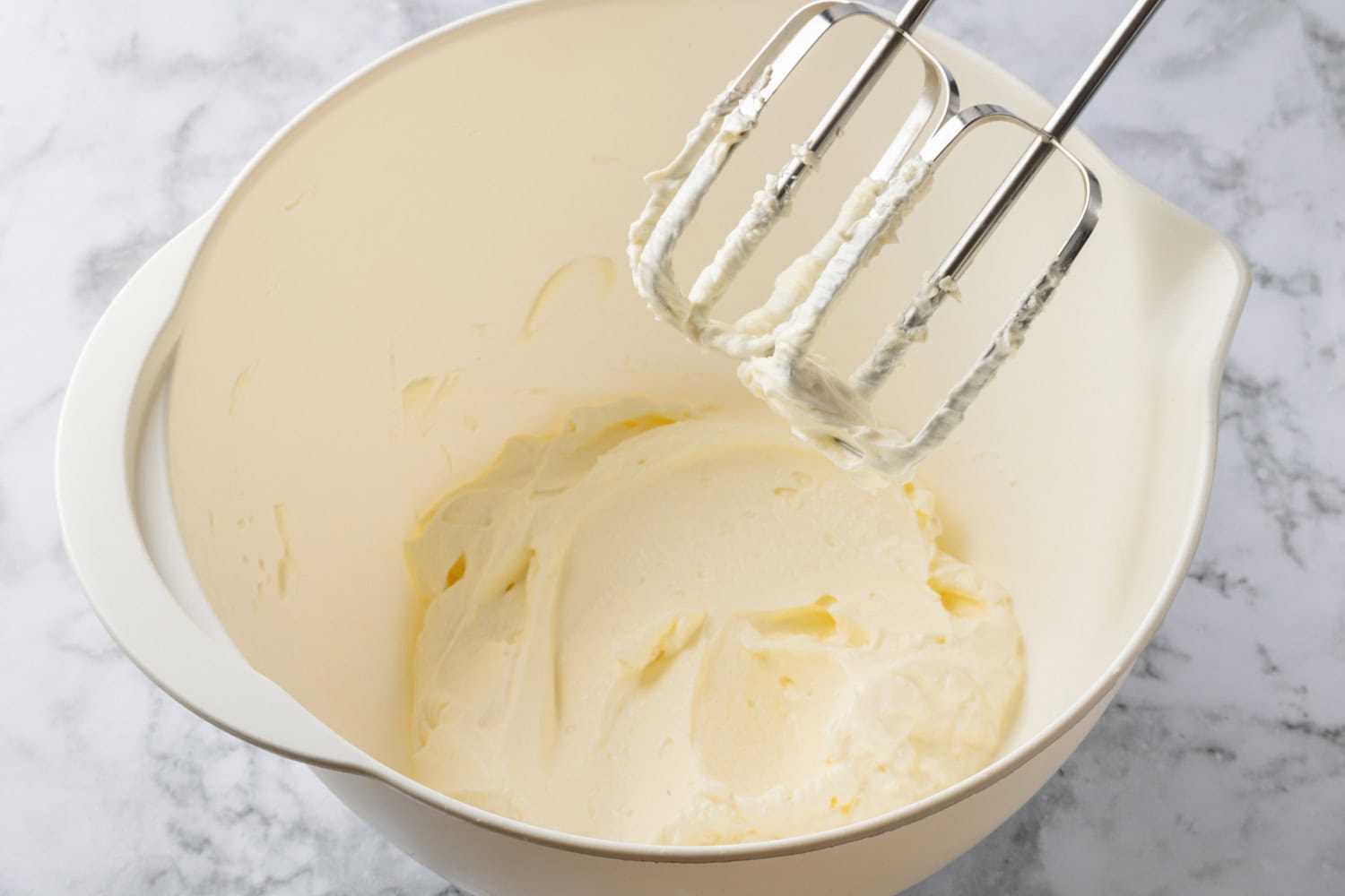 Cream cheese whipped in a mixing bowl.