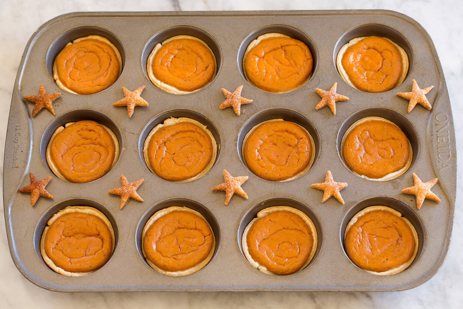 Pumpkin pies shown after baking in muffin pan.