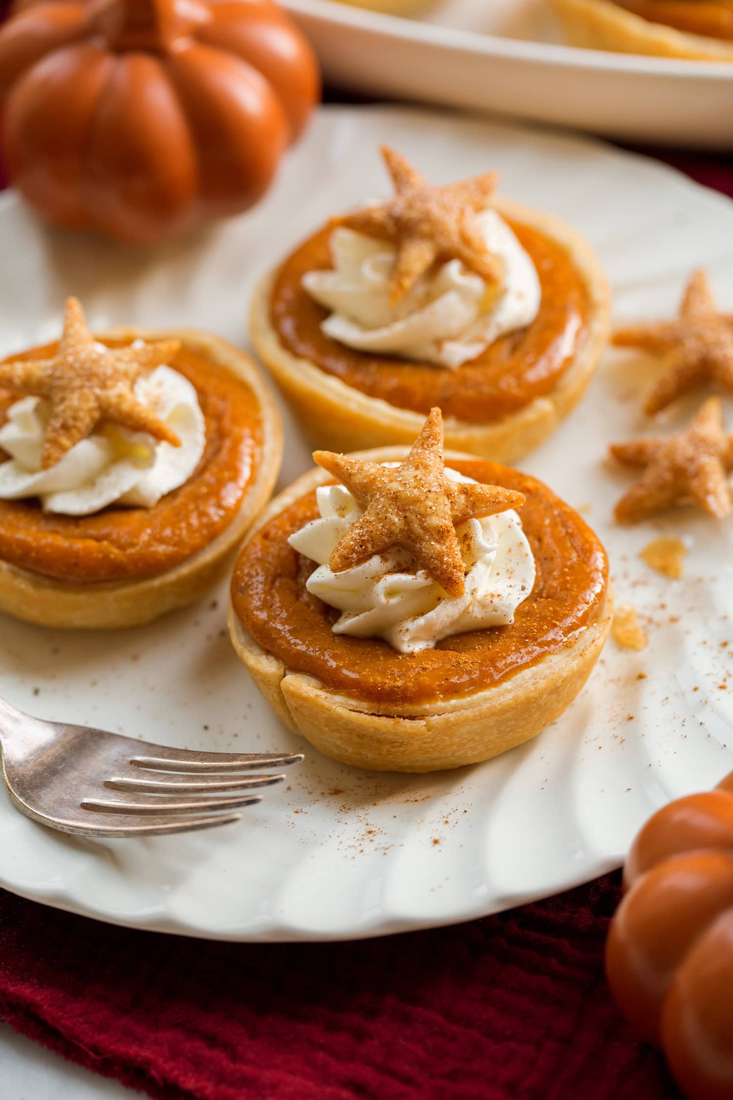 Three mini pumpkin pies on a white plate.