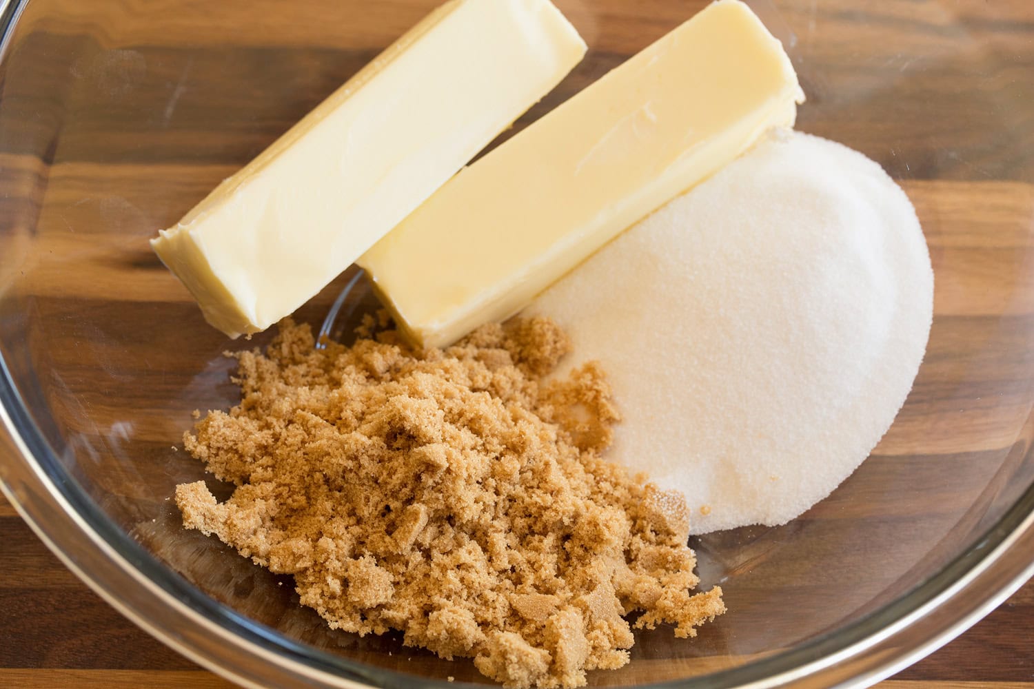 Butter and sugars in a glass mixing bowl before mixing.