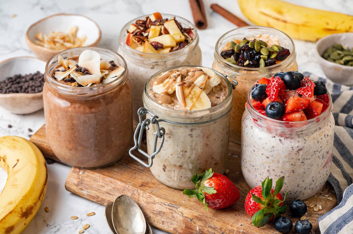 Side angle over jars of oats with yogurt and milk.