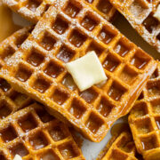 Close up photo of pumpkin waffle with syrup and butter.