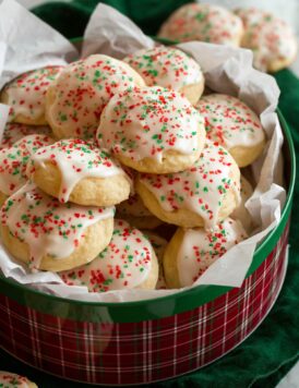 Ricotta cookies stacked in a Christmas tin.