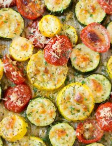 A close up of roasted zucchini and other veg on a roasting pan