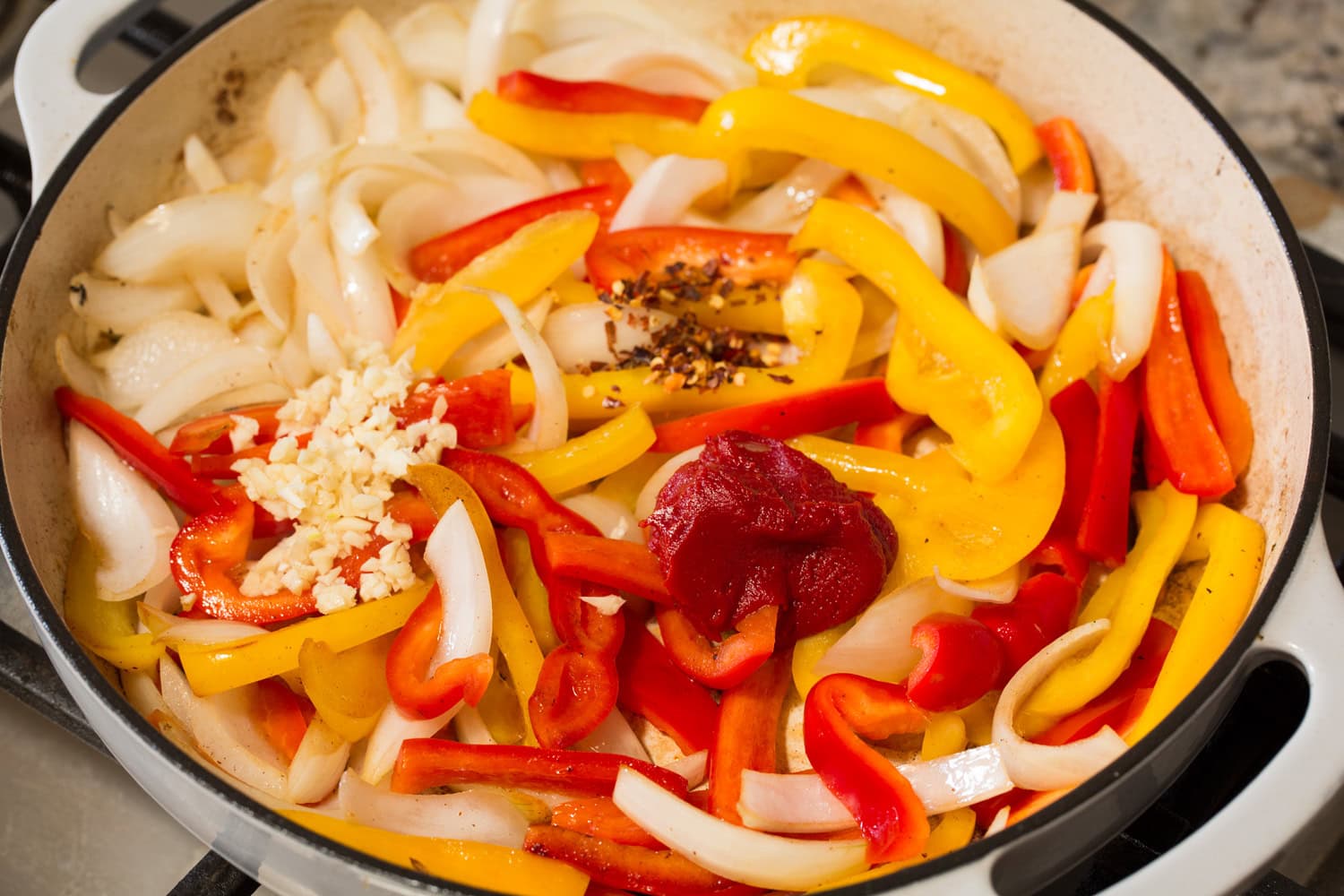 Peppers and onions shown sauteed with tomato paste, garlic and red pepper flakes added.