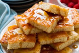 Stack of sheet pan pancakes with butter and syrup.