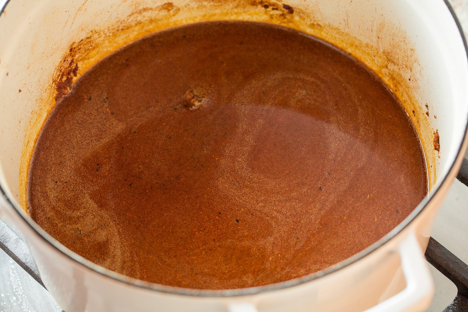 Chili seasonings and broth in a large pot.