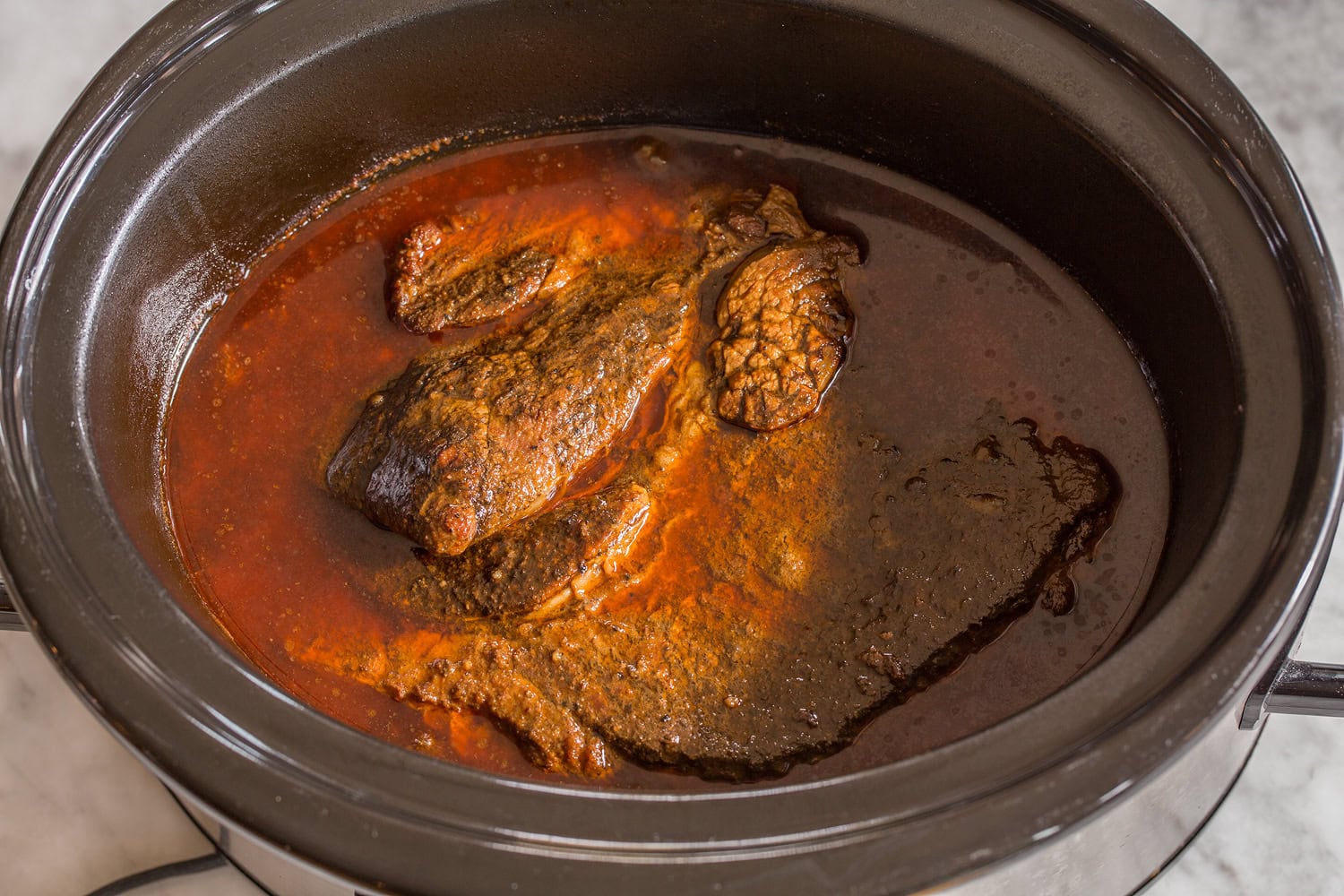 Beef chuck roast finished cooking in slow cooker.