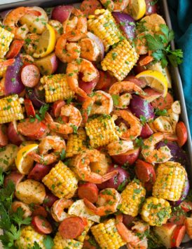 Image shown overhead of shrimp boil after cooking poured out and spread onto a large baking sheet.